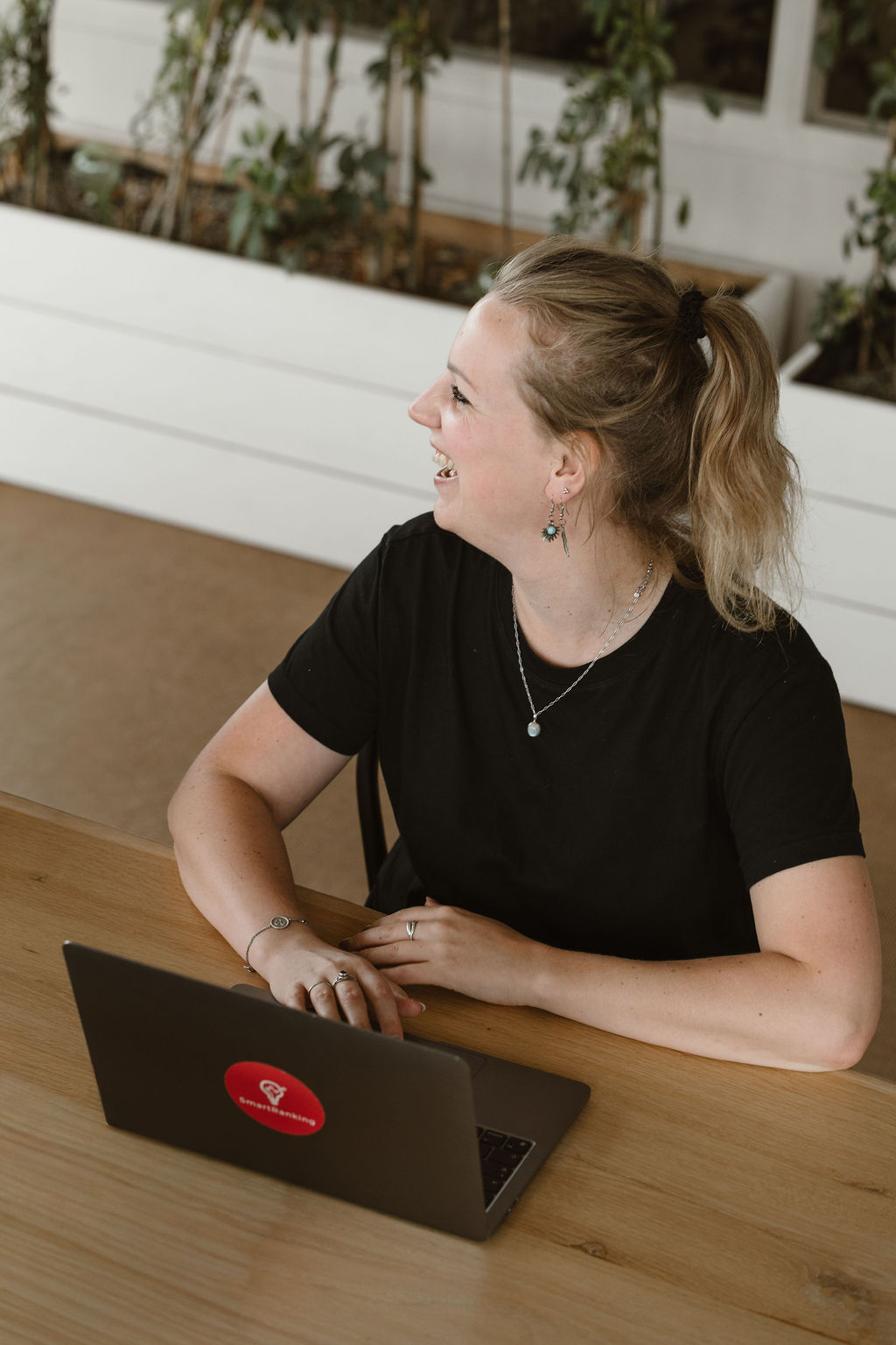 Lachende SmartRanking-collega achter haar laptop