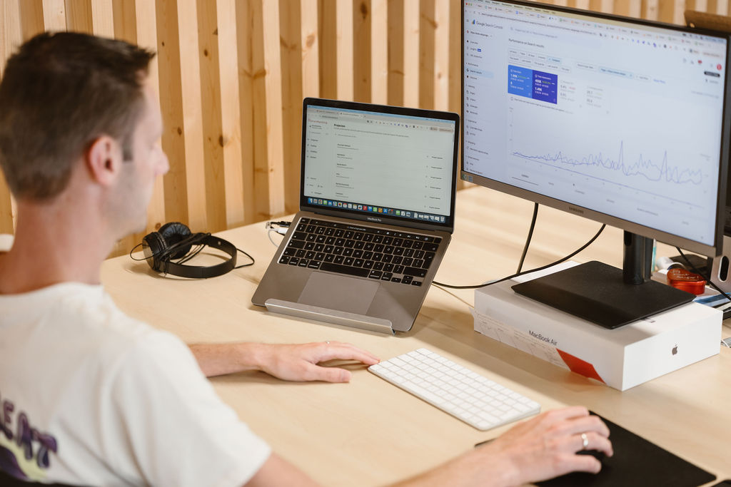 SmartRanking-specialist werkt aan een SEO-analyse achter twee schermen